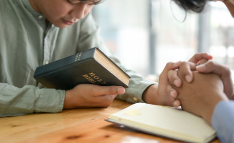 close-up-shot-of-the-bible-and-people-praying